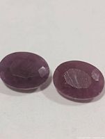 Two oval faceted rubies side by side