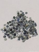 Pile of small round faceted sapphires.