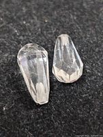 Pair of faceted white quartz stones on dark background