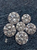 Close-up of six round and one baguette diamond on dark foam pad