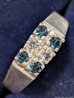 close-up of stone setting showing four blue and two clear stones