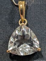 Front view of trilliant green amethyst pendant showing stone, prongs and bail