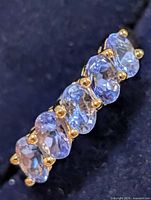 Close-up of five oval tanzanite stones in prong setting