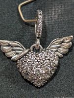 Front view of silver heart pendant with wings and pavé stones