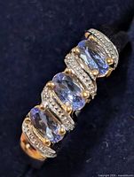 Oblique view of ring showing five tanzanite stones and two-tone metal detail