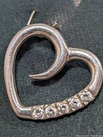 Silver heart earring with five CZ stones, front view