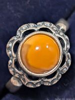 Top view of ring showing orange cabochon and openwork bezel