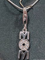 Close-up of pendant spelling MOM with CZ stones
