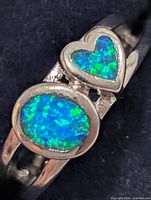Close-up of oval and heart opalite cabochons on ring