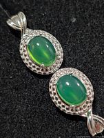 Front view showing two oval green onyx cabochons in silver settings