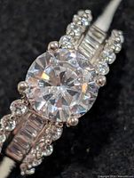 Close view of ring showing round CZ center stone and side accents