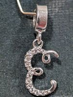 Front angled view of silver CZ E pendant