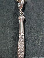 Full view of silver pendant showing bat shape and CZ stones