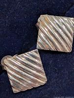 front view of both square ribbed earrings on dark background