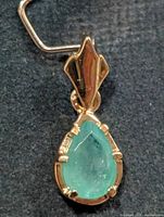 Front view of silver pendant with pear emerald
