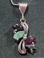 Front view of silver pendant with four marquise gemstones
