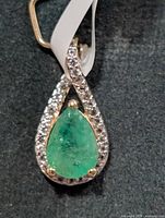 Front view of pendant showing emerald and topaz halo
