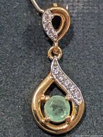 Front view of teardrop pendant showing emerald and CZ accents