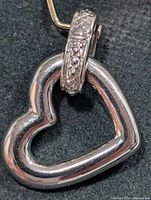 front view of open heart silver pendant with decorative bail