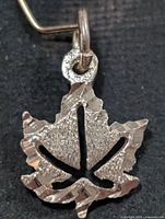 Front view of silver leaf pendant, showing textured surfaces and cut-out design