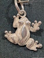 Front view of textured silver frog pendant with jump ring