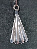 Front view of silver fan-shaped pendant