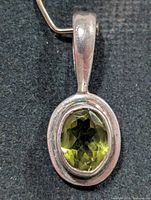 front view of sterling silver pendant with oval green peridot