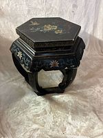 Full view of hexagonal side table showing carved legs and painted apron