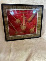 Front view of framed shadow box displaying miniature instruments