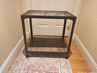 Front angled view of rectangular wood and metal side table showing top and lower shelf