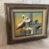 front view of framed canvas art showing pelicans and signature