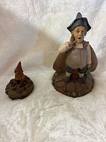 Large and small Tom Clark gnome figurines side by side
