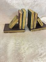 Front angled view of both wooden bookends showing stacked-book design and colour scheme
