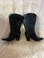 full view of both boots standing upright showing spider web embroidery and block heels