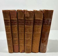 Front spines of all six leather-bound volumes showing titles and gilt decoration