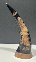 Full view of curved resin horn sculpture with etched eagle