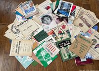 Pile of assorted vintage sheet music and booklets spread on wood floor