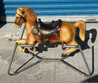 Full view of plastic rocking horse on metal spring frame