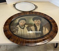 Framed portrait in foreground, mirrored tray in background