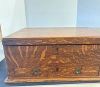 Closed tiger-oak chest front view with lock holes