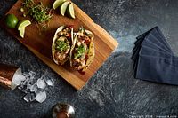 Harbour House Grill food presentation featuring tacos with limes and microgreens on cutting board