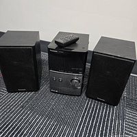 Main unit flanked by two speakers, remote on top