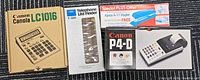 All four boxed items laid out: Canon LC1016 calculator, Carl T-500 list finder, Apsco A-17 stapler set, Canon P4-D printing calculator