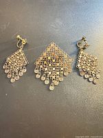 Overall view of two earrings and brooch showing design and size