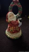 Front view of Fitz & Floyd Santa bell showing Santa figure, wreath handle, inscription