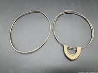 Both gold-tone collar necklaces side by side