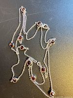 Full view of sterling silver chain showing length and red bezel stones