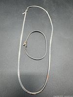 Necklace and bracelet laid out to show length and style