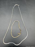 Necklace and bracelet laid out on black surface