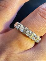 Close-up of the ring on finger showing clear stones and silver bars